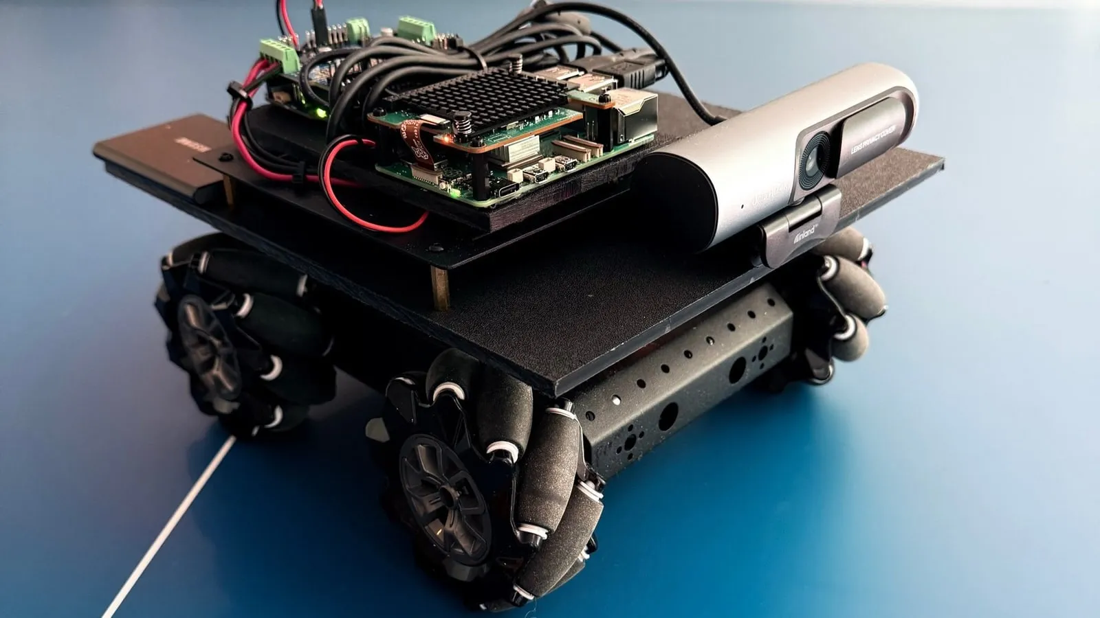 The autonomous rover, a small four-wheeled robot, on the workshop floor